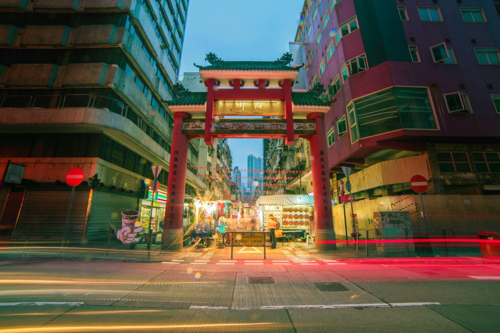 pexels-photo-946630-946630 Colorful street view of Mong Kok with vibrant nightlife and traditional Chinese gate in Kowloon, Hong Kong.